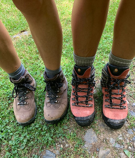 2 persons standing in tramping shoes